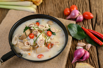 Tom Kha Kai in a pan frying with kaffir lime leaves, lemongrass, red onion, galangal and chilli.