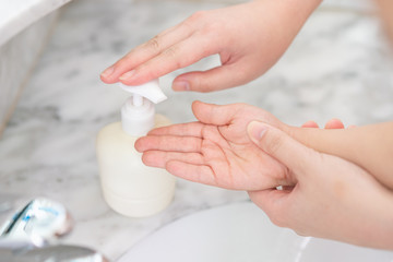 Young asian woman washing hands for her son
