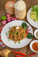 Spicy minced pork on a white plate and sticky rice box
