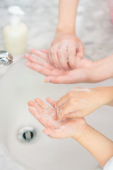 Young asian woman washing hands for her son