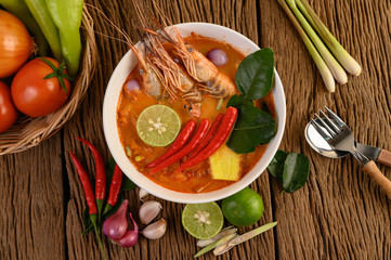 Tom Yum Kung Thai hot spicy soup shrimp with lemon grass,lemon,galangal and chilli on wooden background Thailand Food