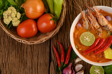 Tom Yum Kung Thai hot spicy soup shrimp with lemon grass,lemon,galangal and chilli on wooden background Thailand Food