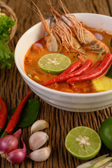 Tom Yum Kung Thai hot spicy soup shrimp with lemon grass,lemon,galangal and chilli on wooden background Thailand Food