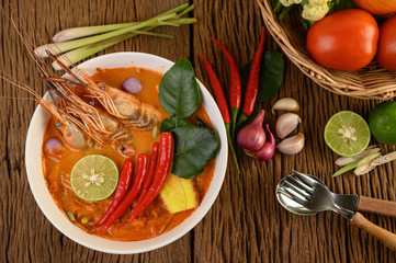Tom Yum Kung Thai hot spicy soup shrimp with lemon grass,lemon,galangal and chilli on wooden background Thailand Food