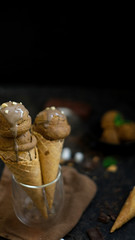 Cropped shot of summer dessert with chocolate flavour ice-cream cones in glass