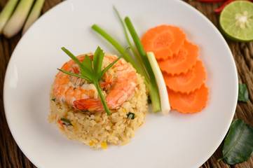 Shrimp fried rice on a white plate on a wooden table