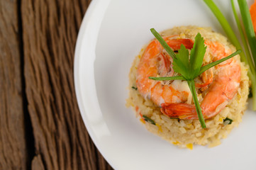Shrimp fried rice on a white plate on a wooden table