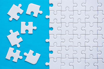 Jigsaw puzzle white color on blue color background copy space for text,Top view