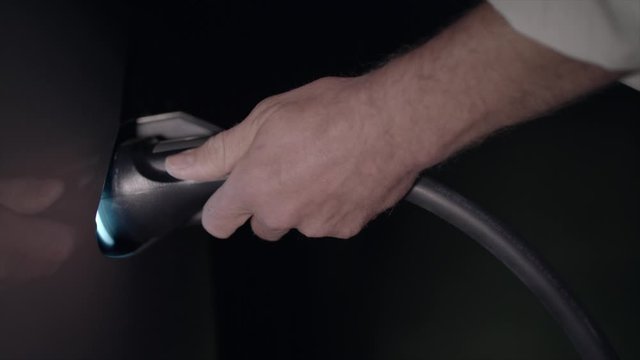 Tesla Model S being charged with electric flap opening and closing night