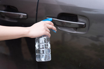 Asian women disinfect and clean the handle of car door