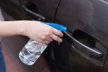 Asian women disinfect and clean the handle of car door