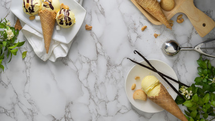 Top view of vanilla ice-cream cones with topping and copy space on marble desk