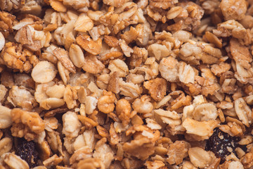 Useful and tasty muesli with nuts, rasins and flakes. Selective focus macro shot with very shallow depth of field. Healthy and vegetarian lifestyle