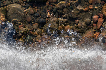 Spring background: curly edge of melting ice, clear river water