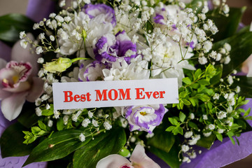Best mom ever writing love text for mother on paper. lovely message for mothers day.Bouquet of Gypsophila, orchids,Lisianthus and best mom ever text on a note