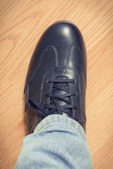 Casual navy blue leather shoe on board, male footwear concept