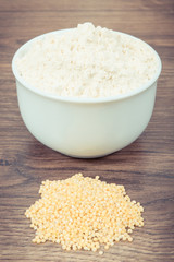 Vintage photo, Heap of millet groats and flour in glass bowl, healthy and gluten free food