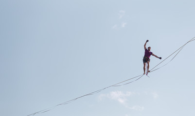 Highliner on the background of blue sky.