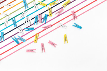 many strands of colorful strings line on white background. 11 eleven straight colorful threads and cloths peg.