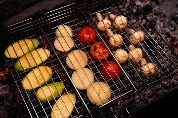 Tasty vegetables and mushrooms in grill grate