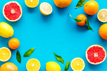 Citrus fruits - lemons, grapefruits - on blue background mockup, frame top-down copy space