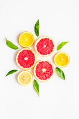 Citrus pattern. Lemon and grapefruits slices and leaves on white background top-down copy space