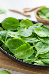 Fresh green leaves spinach on a wooden cutting board