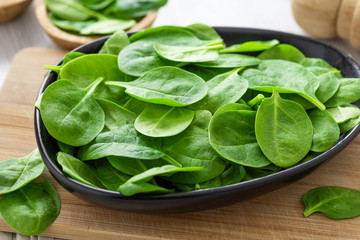 Fresh green leaves spinach on a wooden cutting board