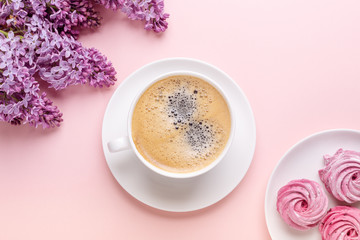 Obraz na płótnie Canvas Morning Cup of coffee and a beautiful lilac flowers on pink background, top view. Cozy Breakfast. Flat lay style.