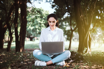 Happy student woman using laptop computer at public park in the morning,Happy and smiling,Relaxing time