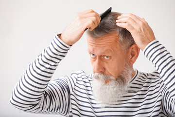 Senior man with hair loss problem at home