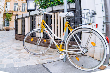 Fototapeta na wymiar old retro yellow bike at european city street