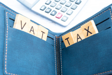 taxx and vat keyword on wood block in the money wallet with finance paper