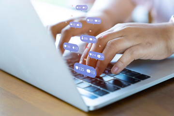 Obraz premium Person using a social media marketing concept on computer tablet with notification icons of like, chat, message and comment above tablet screen.