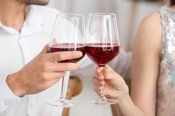 Happy young couple drinking wine on romantic date in cafe, closeup