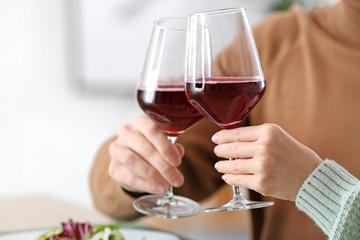 Happy young couple drinking wine on romantic date in cafe, closeup