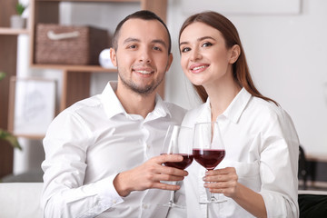 Happy young couple drinking wine on romantic date at home