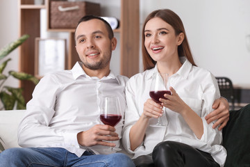 Happy young couple drinking wine on romantic date at home