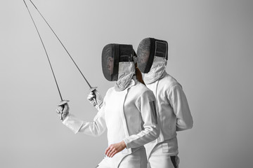 Young fencers on light background