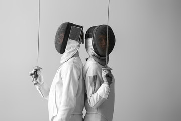 Young fencers on light background