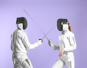 Young fencers on color background
