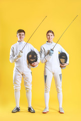 Young fencers on color background