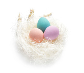 Nest with beautiful Easter eggs on white background