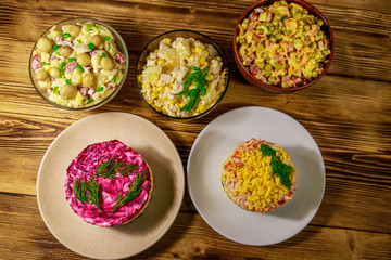 Set of festive mayonnaise salads on wooden table. Top view