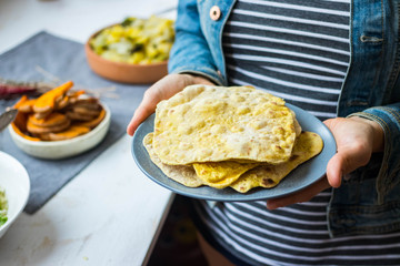 Chapati naan paratha flatbread. Woman holds Indian homemade bread. Vegan healthy diet food.
