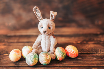 Colorful easter eggs and easter hand made rabbit on wooden background