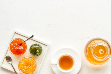 Fruit jam near tea on white kitchen desk frame copy space