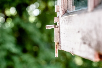 White window latch with bokeh nature background 