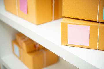 parcels in brown wrapping paper and blank tags or labels on the shelf ready for deliver.on line...