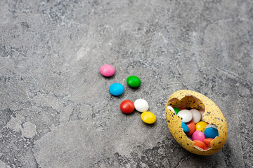 Easter Eggs with sweets over gray background